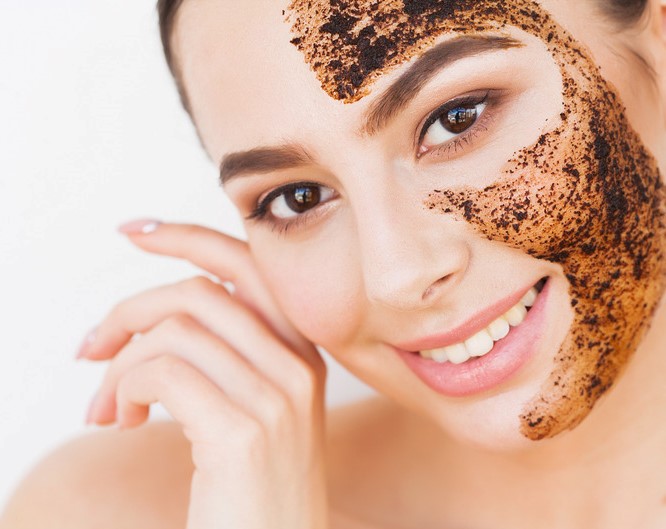 Face Skin Scrub. Smiling Girl Applying Coffee Mask Scrub On Skin.